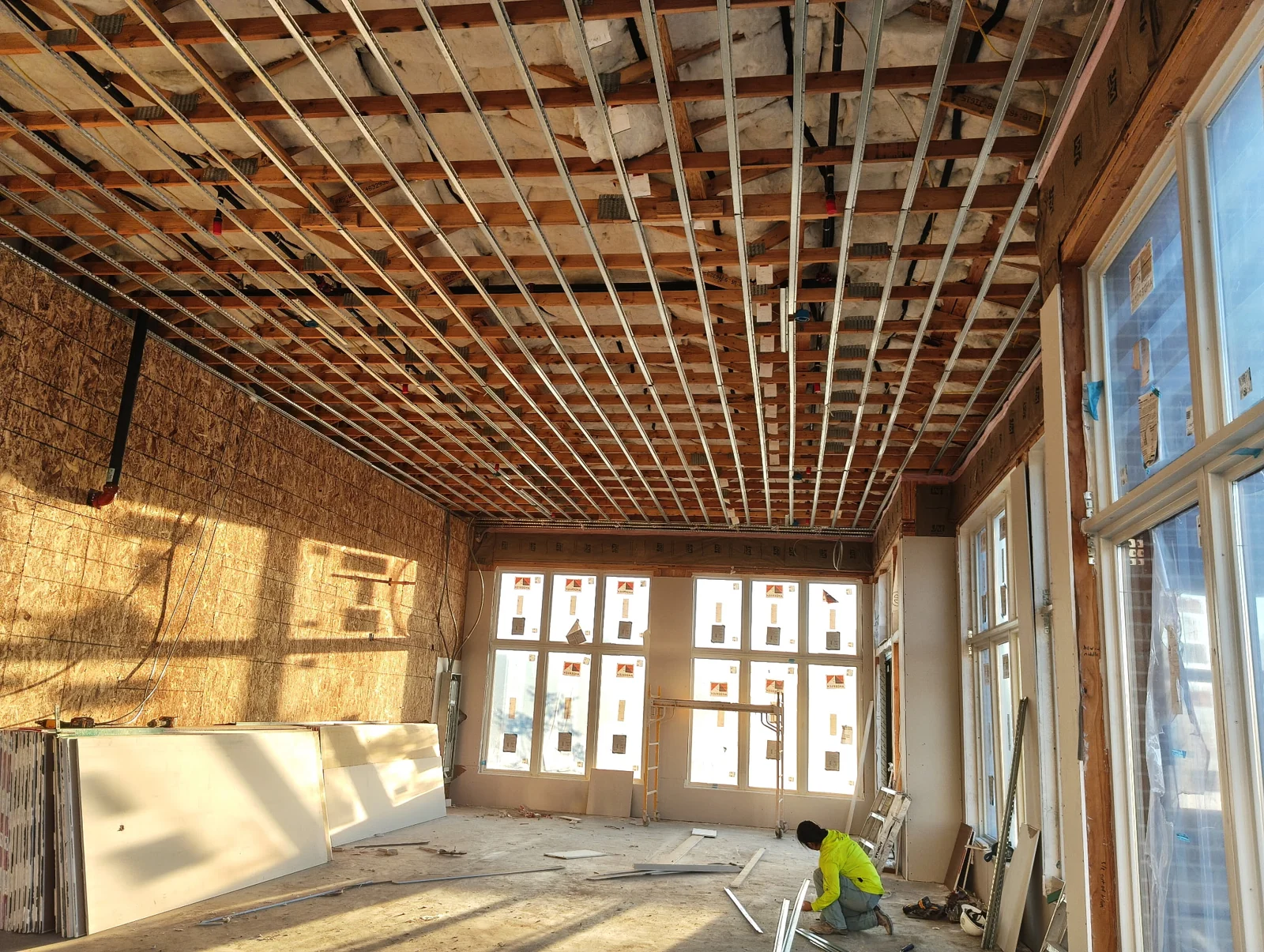 Jireh TH Construction crew preparing a sunlit interior for drywall installation